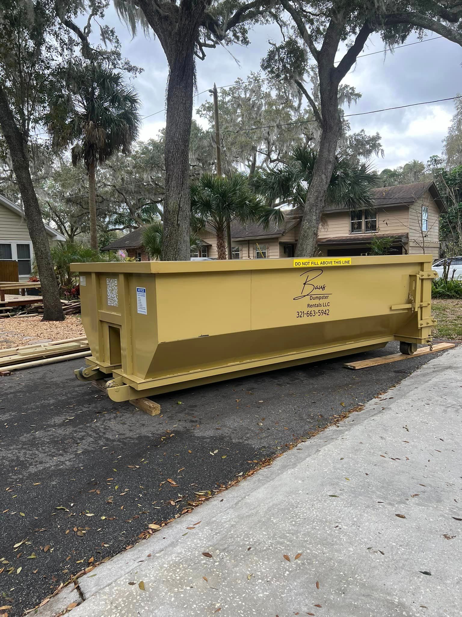 Yellow Baus 15 yard roll-off dumpster on a residential street in Orlando, FL