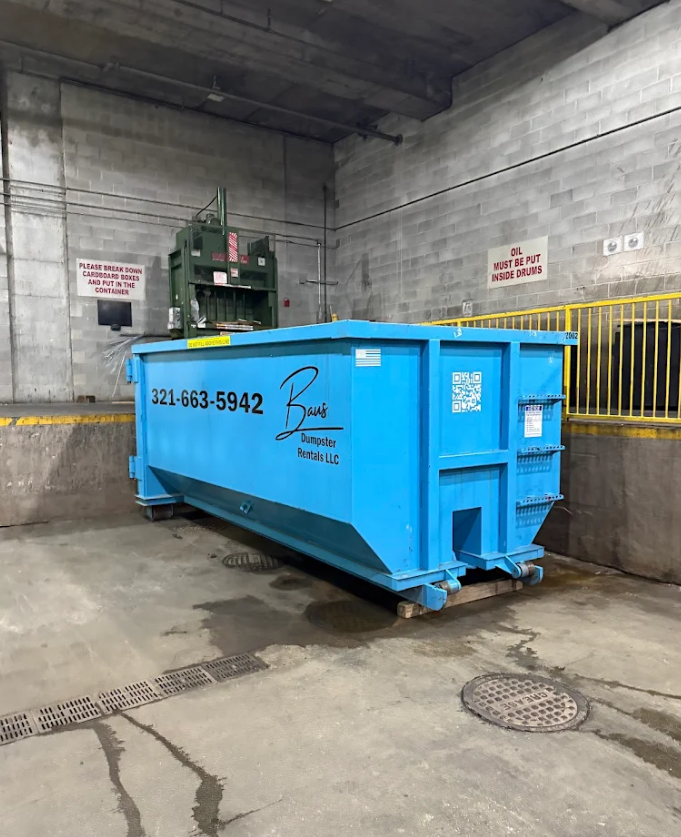 Blue Baus commercial roll-off dumpster at a loading dock in Orlando, FL