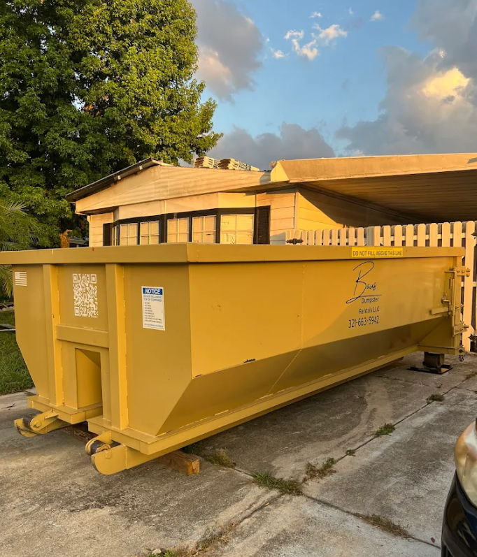 Yellow Baus 15 yard roll-off dumpster at a home in Orlando, FL