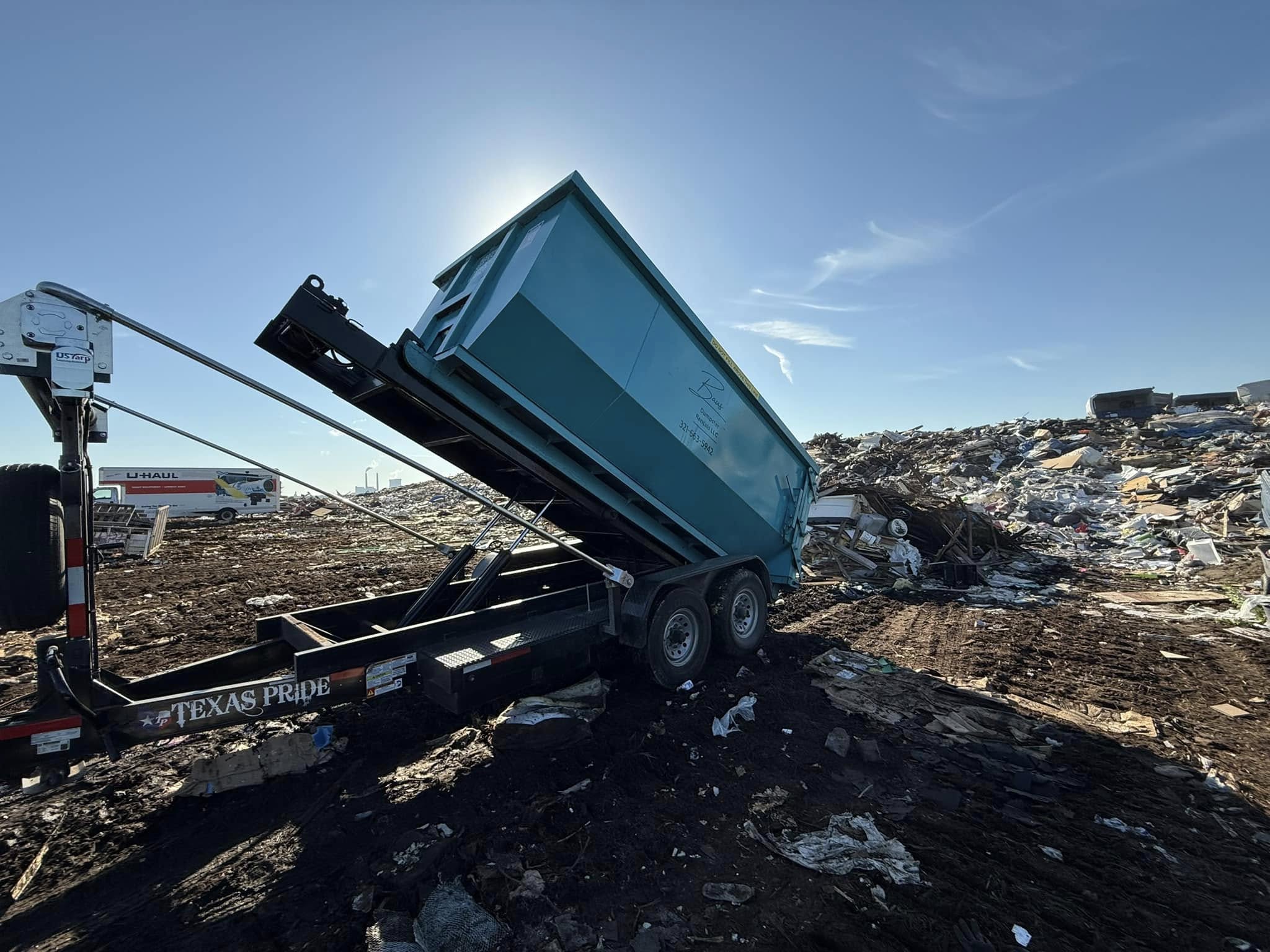 Teal Baus 20 yard roll-off dumpster being unloaded in Kissimmee, FL