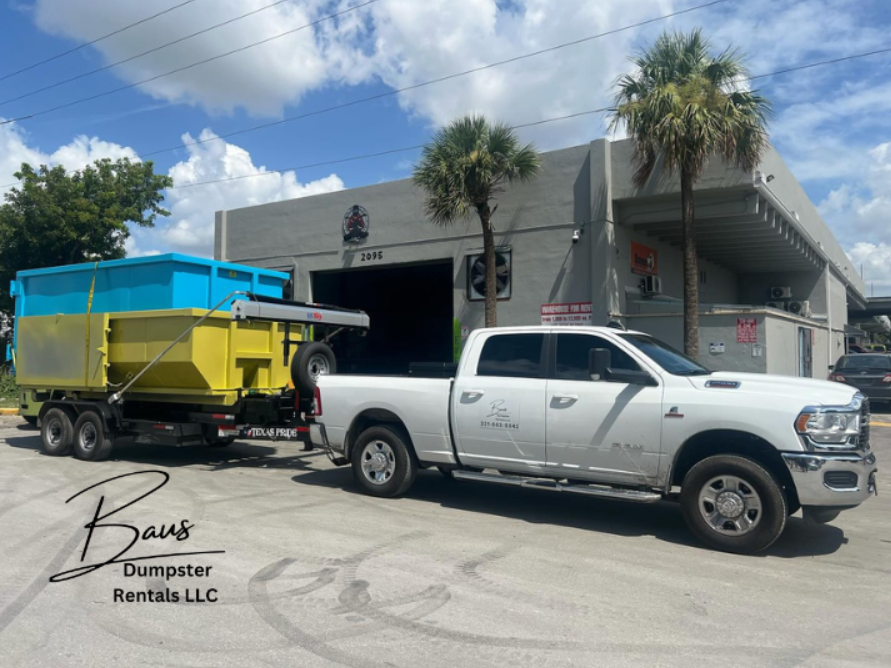 Baus Dumpster Rentals truck towing blue and yellow roll-off dumpsters in Orlando, FL